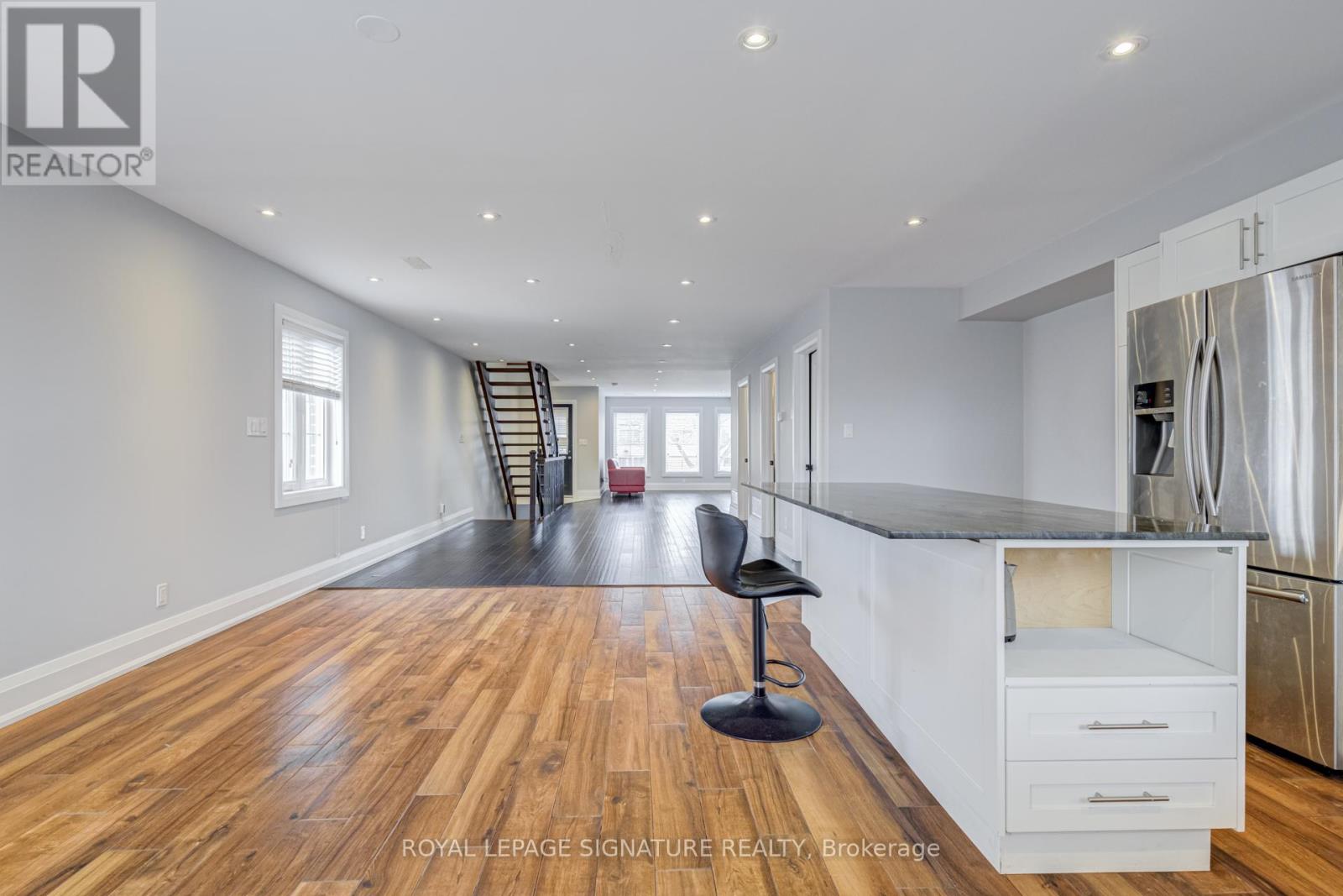 A spacious kitchen with white cabinets and a black countertop.