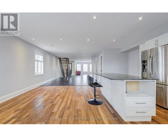 A spacious kitchen with white cabinets and a black countertop.