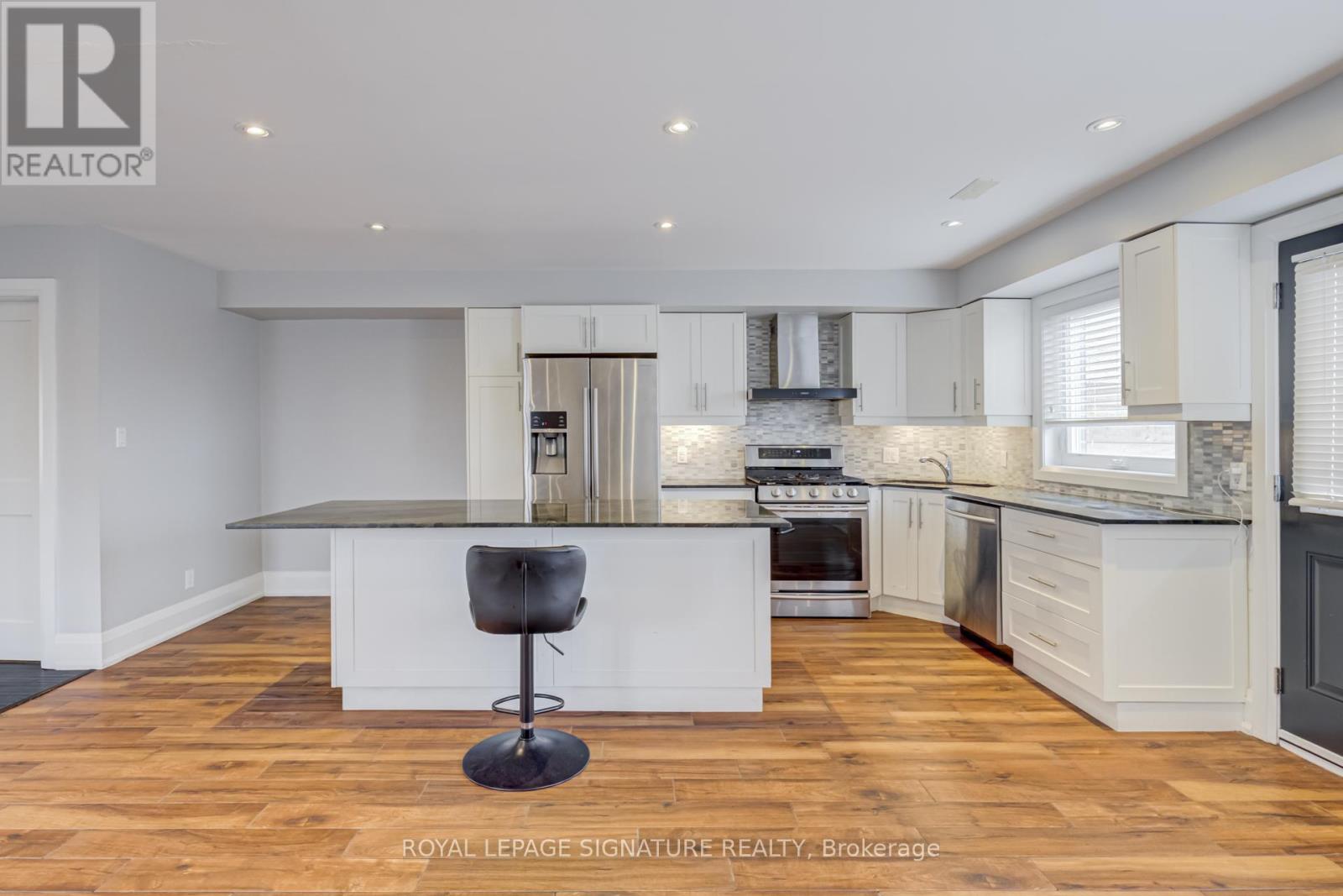 A modern kitchen with a bar stool in the middle.