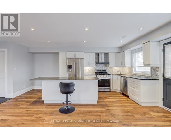 A modern kitchen with a bar stool in the middle.