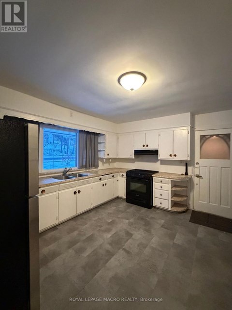 A kitchen with white cabinets and a black oven.