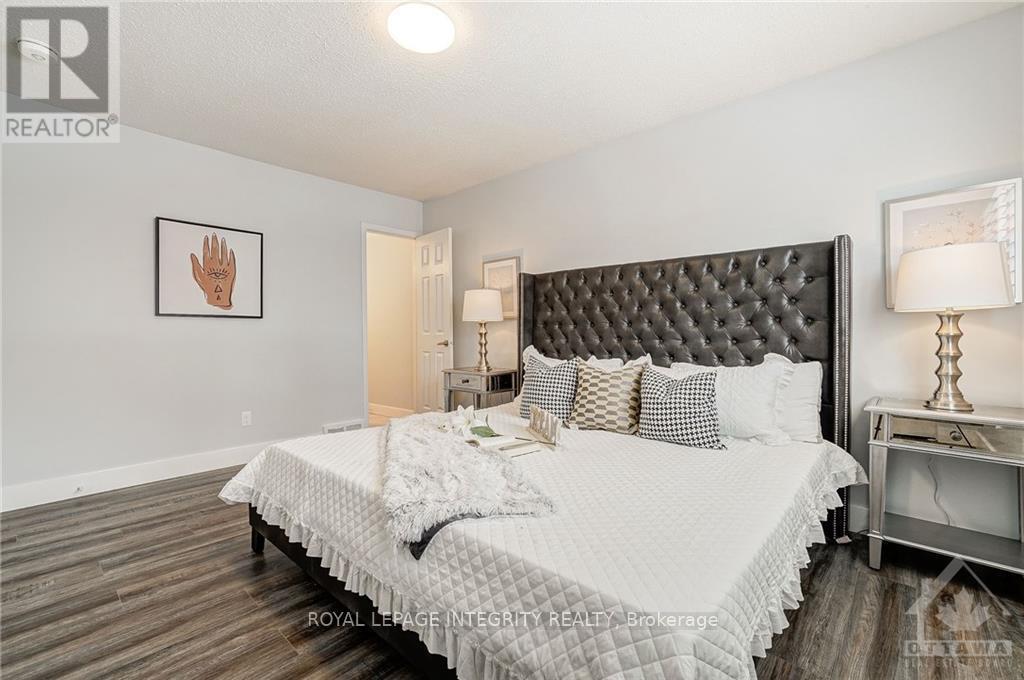 A bedroom with a large bed and a wooden floor.