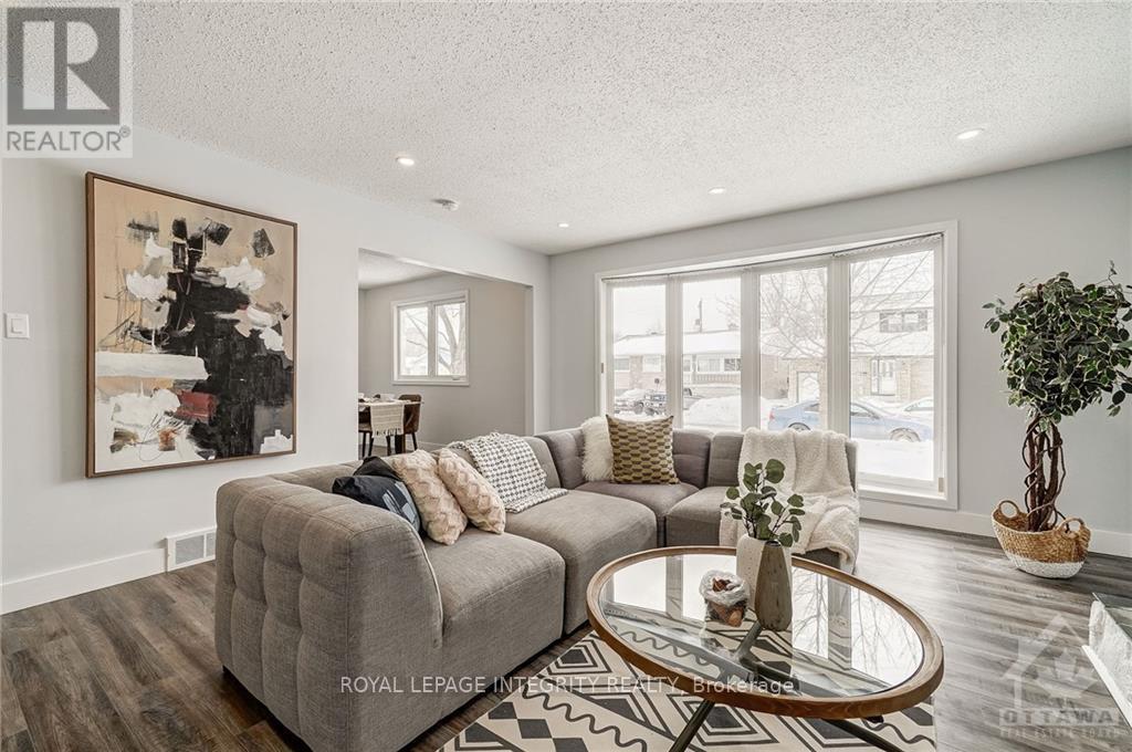 A living room with a grey couch, a coffee table, and a painting on the wall.