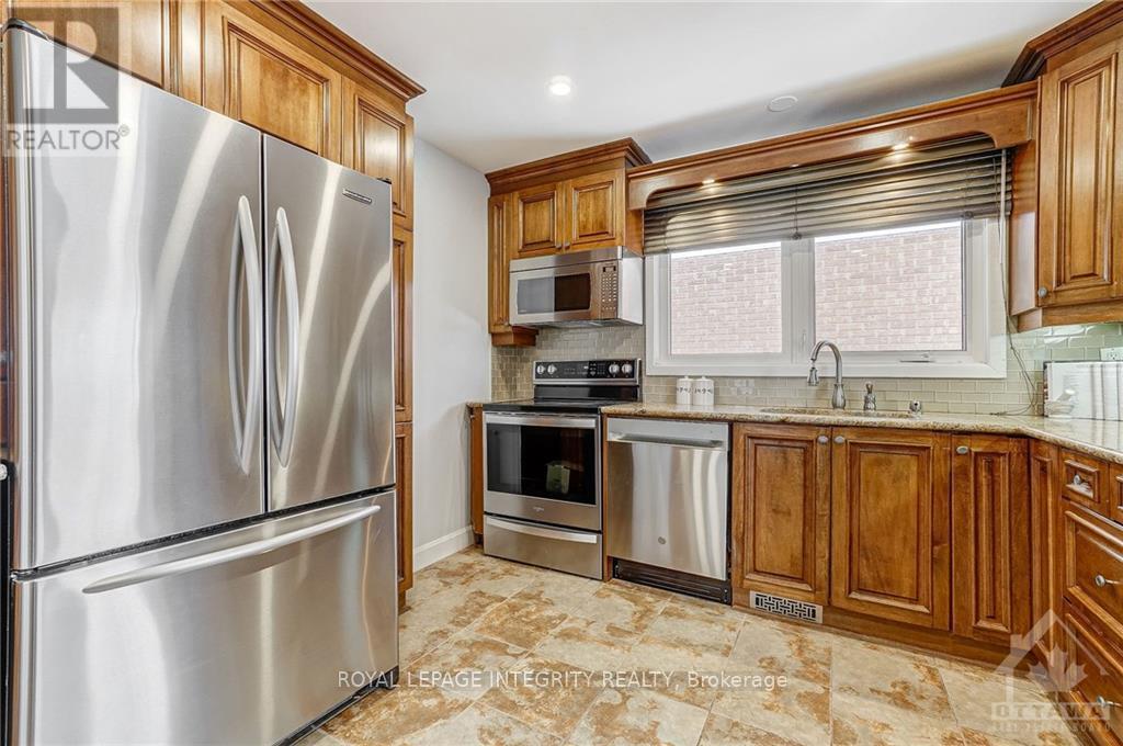 A kitchen with a stainless steel refrigerator and wooden cabinets.