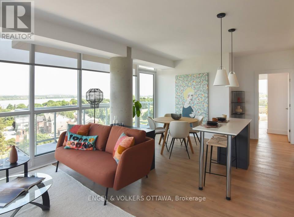 A living room with a couch, chairs, and a dining table.