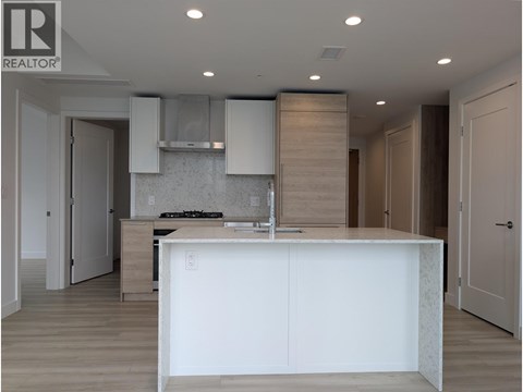 A modern kitchen with a large island and wooden cabinets.