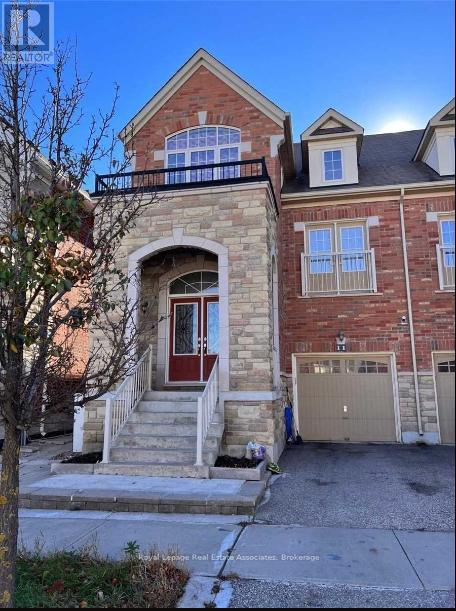 A two-story brick house with a balcony on the upper floor.
