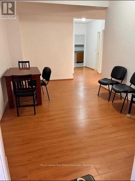 A room with a wooden floor and a table with chairs.