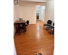 A room with a wooden floor and a table with chairs.
