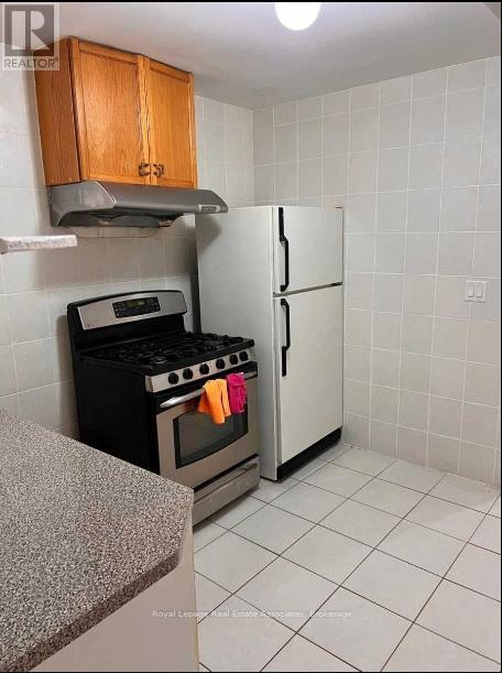 A kitchen with a stove, oven, and refrigerator.