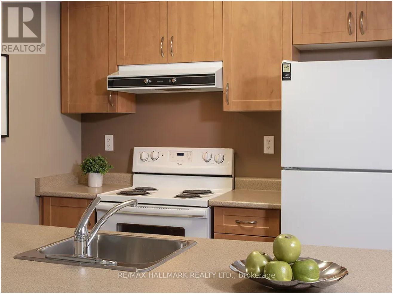 A kitchen with a white refrigerator, stove, and sink.