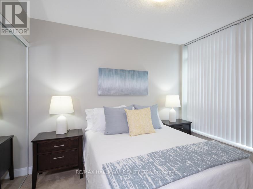 A bedroom with a bed, nightstands, and lamps.