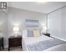 A bedroom with a bed, nightstands, and lamps.