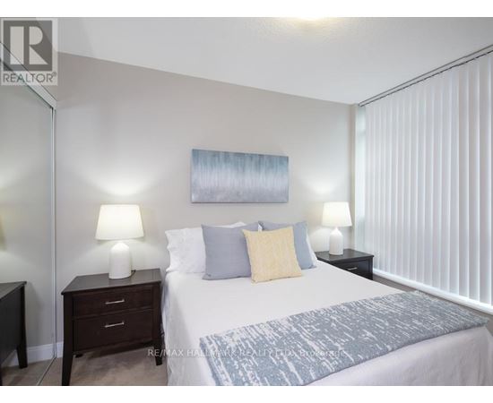 A bedroom with a bed, nightstands, and lamps.
