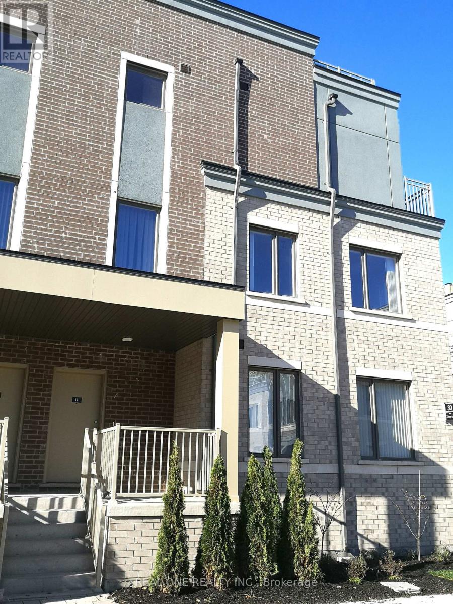 A two-story brick building with a balcony and a small garden in front.