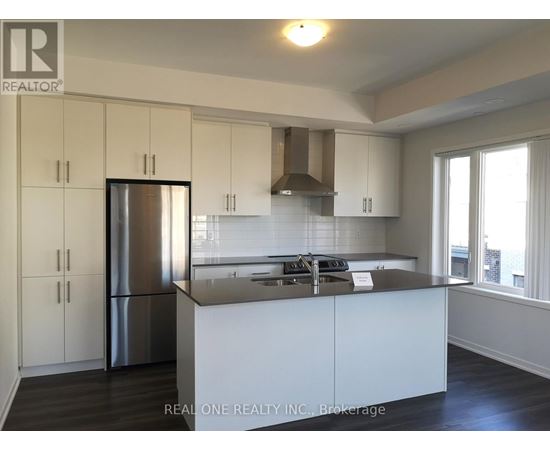 A kitchen with white cabinets and a stainless steel refrigerator.