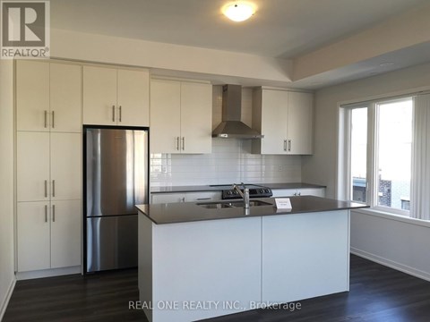 A kitchen with white cabinets and a stainless steel refrigerator.