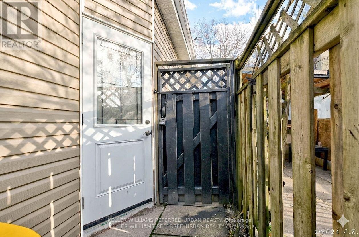 A wooden fence with a gate in front of a house.