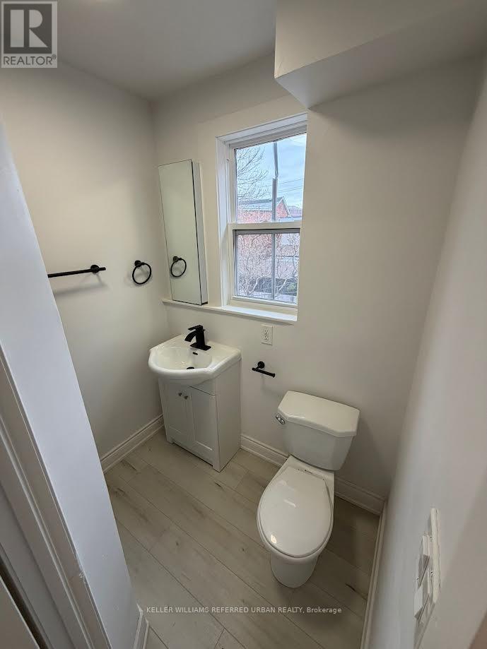 A white toilet and sink in a small bathroom.