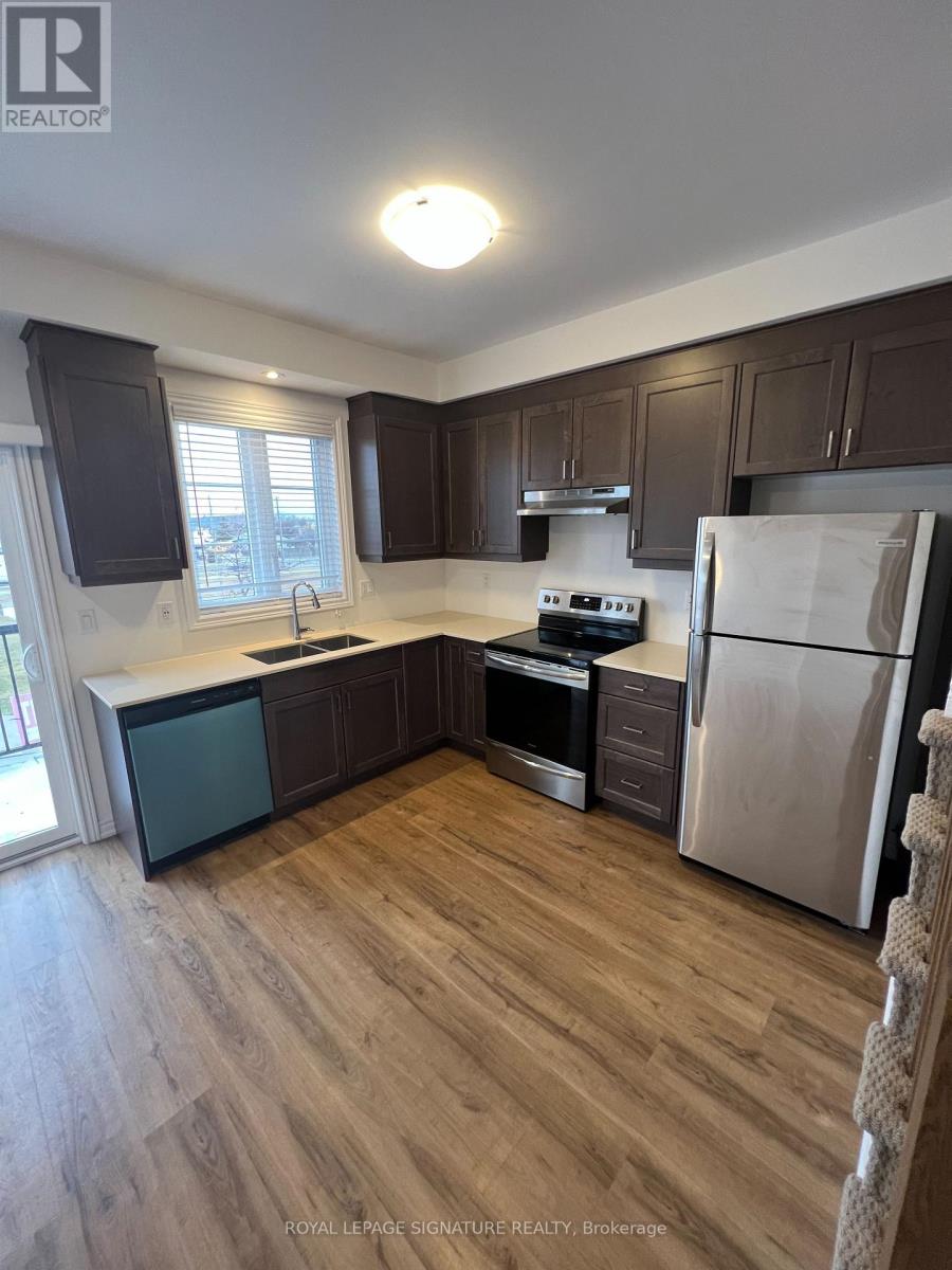 A kitchen with wooden floors and stainless steel appliances.