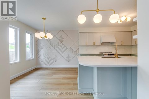 A kitchen with a white counter top and a wall with a geometric pattern.
