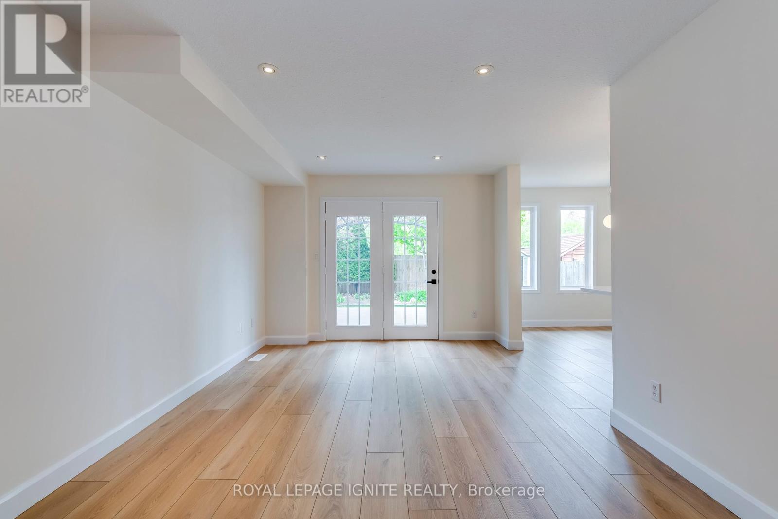 A spacious room with wooden floors and white walls.