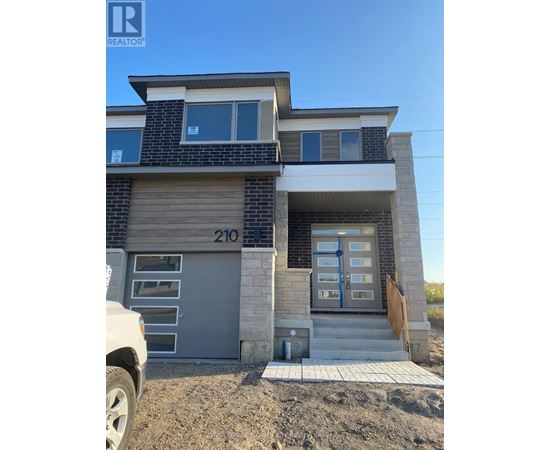A modern two-story house with a garage door numbered 210.