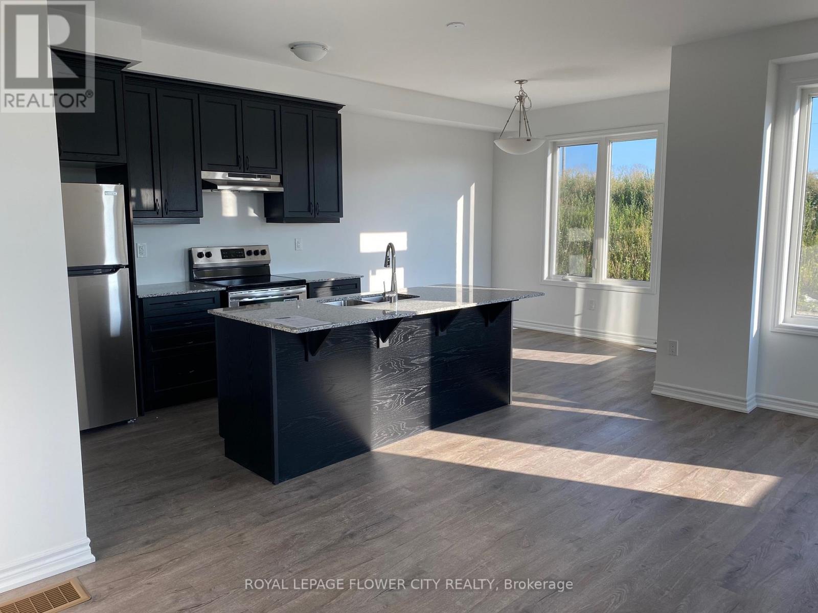 A kitchen with black cabinets and a black island.