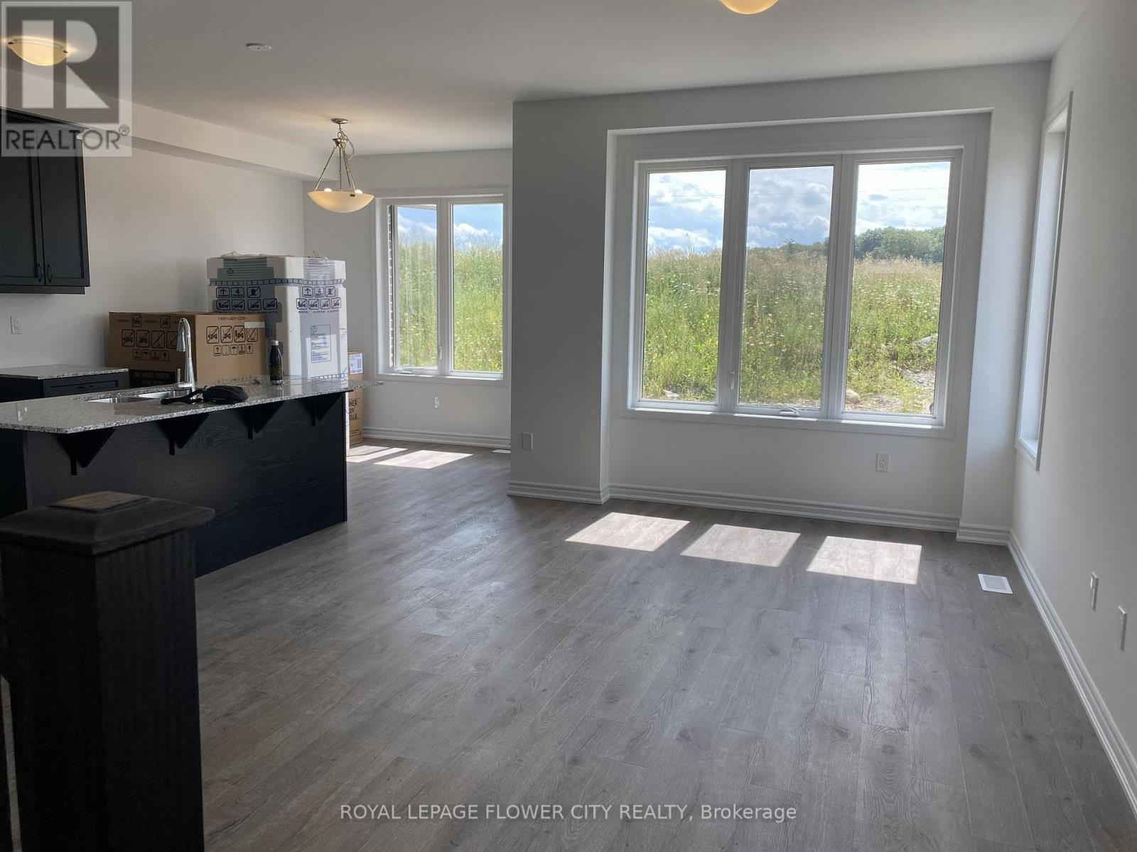 A room with a large window and a kitchen area.