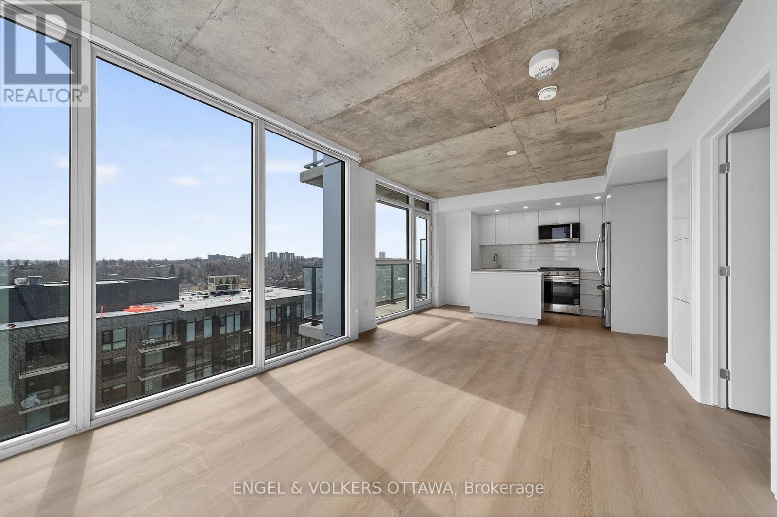 A large, empty room with a view of the cityscape outside the windows.