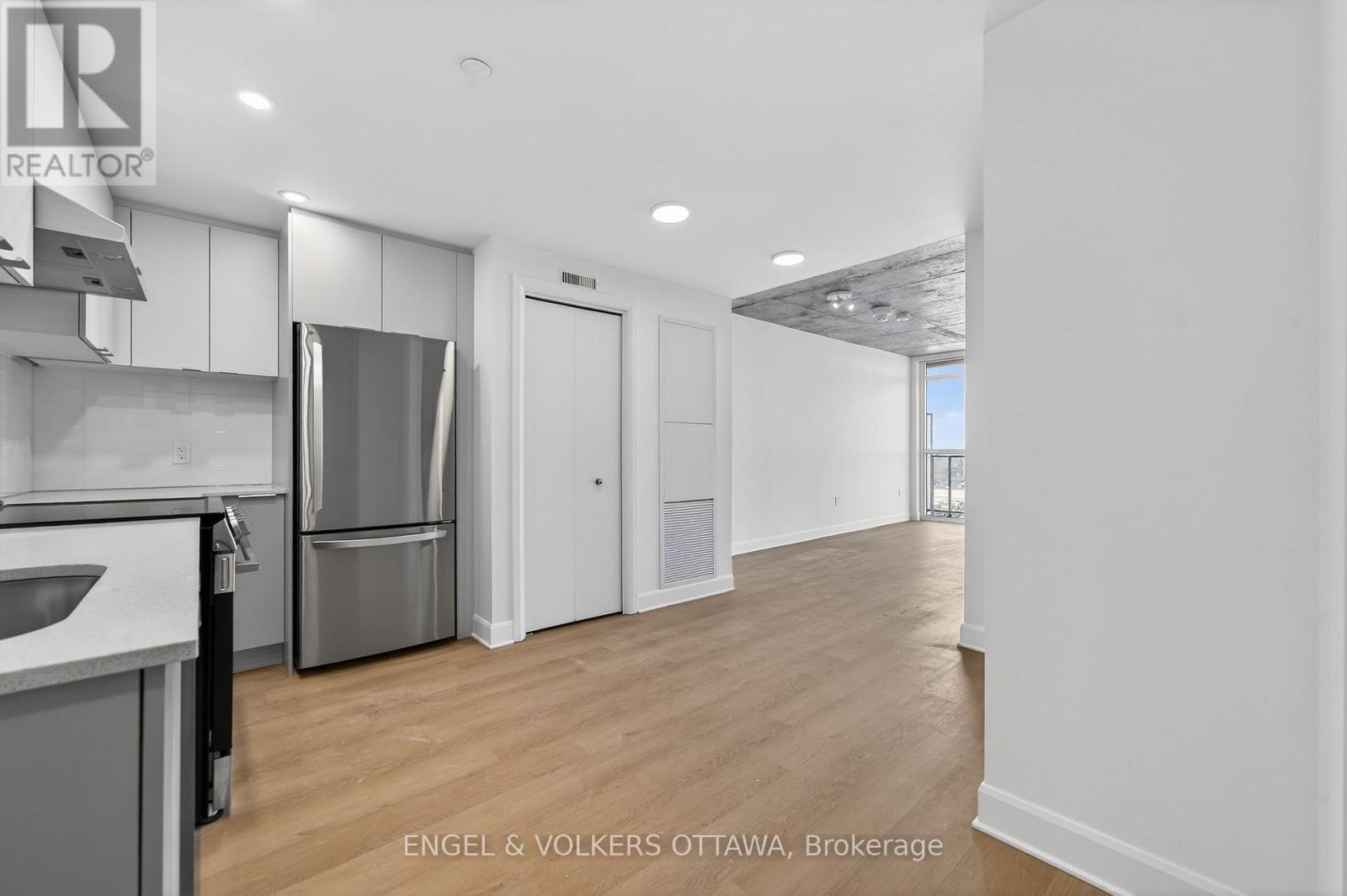 A modern kitchen with white cabinets and a stainless steel refrigerator.