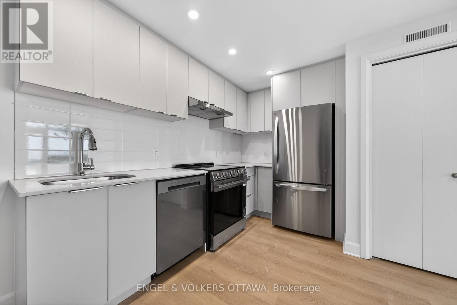 A modern kitchen with white cabinets and stainless steel appliances.