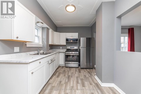 A modern kitchen with white cabinets and stainless steel appliances.