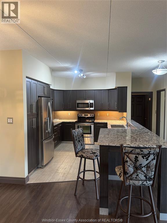A kitchen with a granite counter top and bar stools.