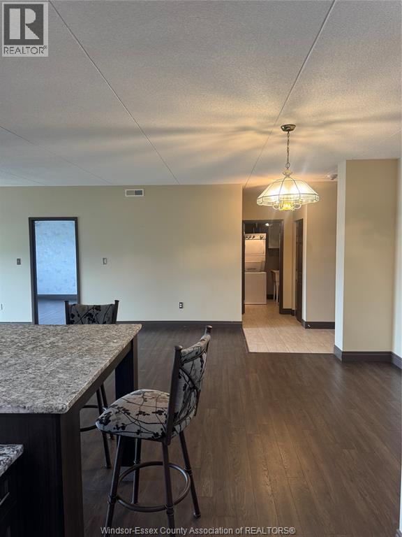 A kitchen with a bar stool and a dining table.