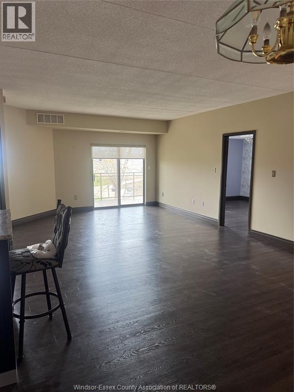 A room with a wooden floor and a chair with a white pillow on it.