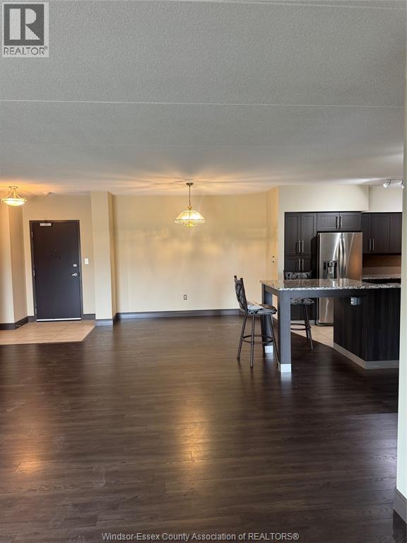 A kitchen with a black fridge and a black chair.