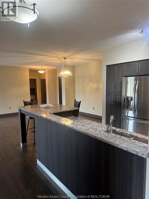 A kitchen with a granite countertop and stainless steel appliances.