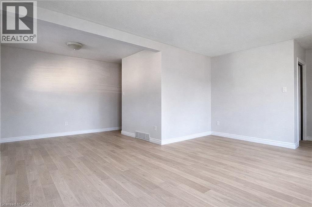 A room with wooden flooring and white walls.