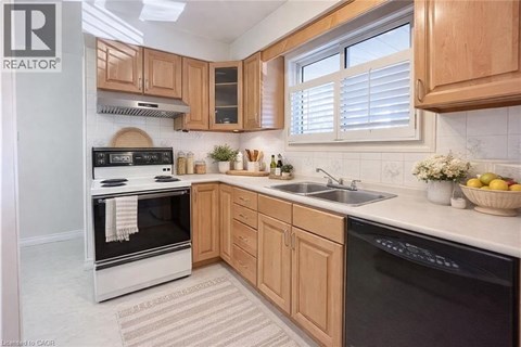 A kitchen with wooden cabinets and black appliances.
