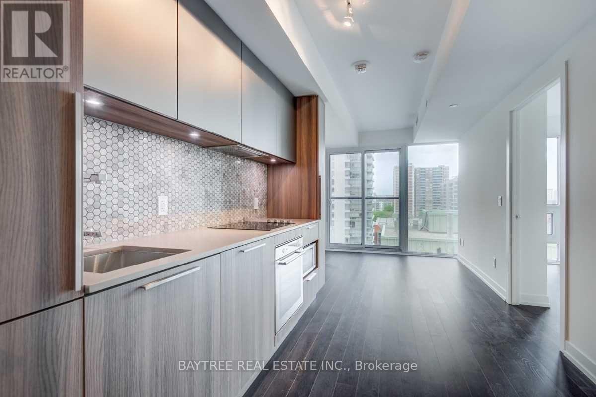 A modern kitchen with wooden cabinets and a glass backsplash.