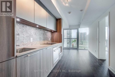 A modern kitchen with wooden cabinets and a glass backsplash.