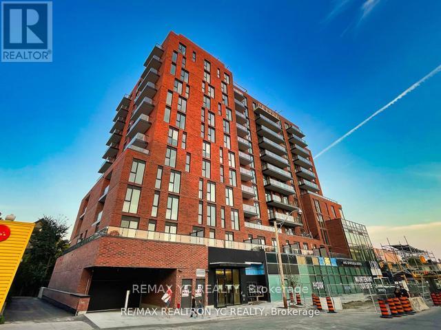A tall red brick building with the words RE/MAX REALTY, REALTY, BROKERAGE on the front.