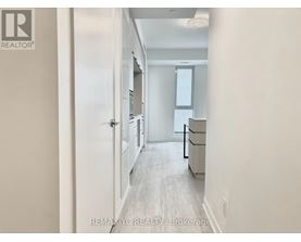 A hallway with a door on the left and a window on the right.