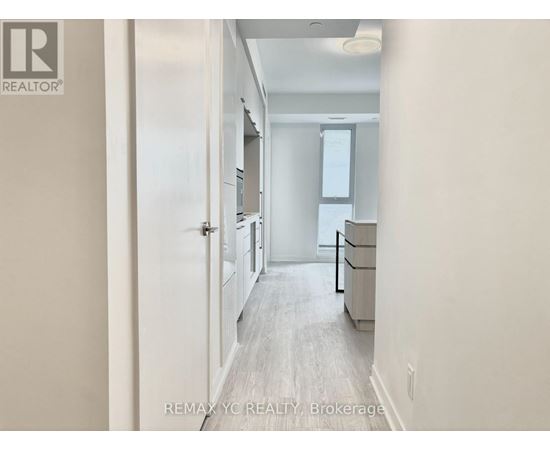 A hallway with a door on the left and a window on the right.