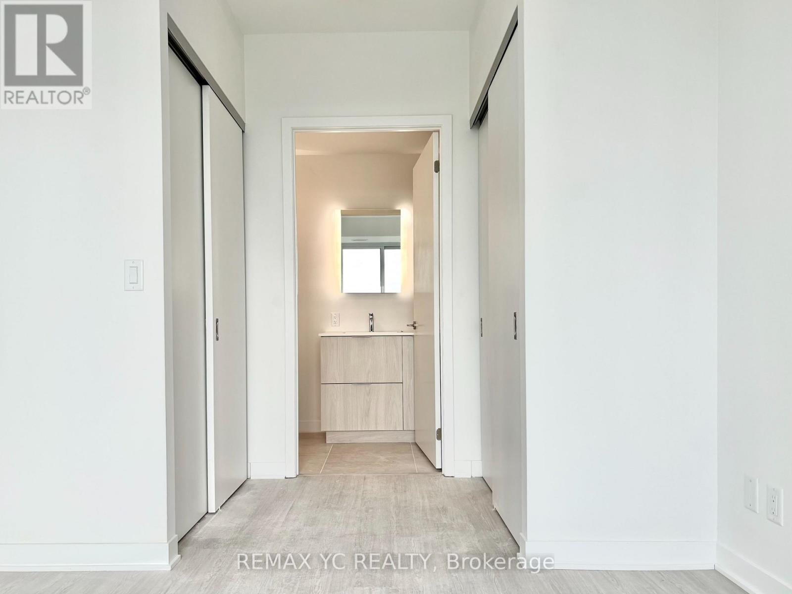 A hallway with a doorway leading to a bedroom.
