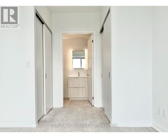 A hallway with a doorway leading to a bedroom.