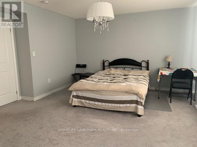 A bedroom with a bed, desk, and chair.