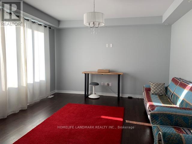A living room with a red rug, a sofa, and a table.