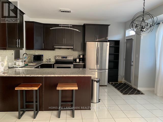 A kitchen with dark brown cabinets and a stainless steel refrigerator.